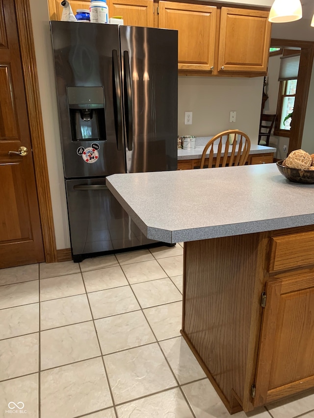 kitchen featuring light tile patterned floors and stainless steel fridge