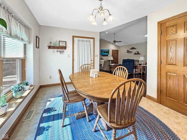 dining room with light tile patterned floors, vaulted ceiling, and ceiling fan with notable chandelier