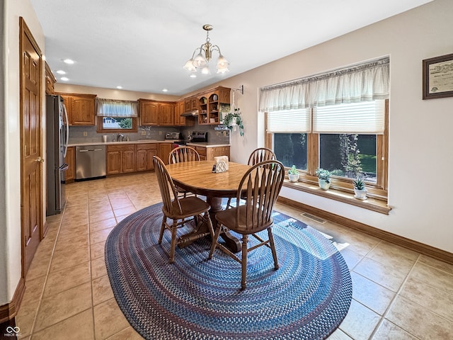 tiled dining space with sink and a chandelier