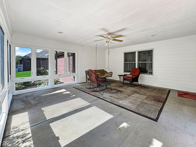 unfurnished sunroom featuring ceiling fan