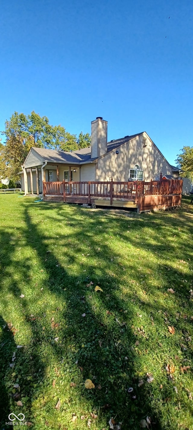 rear view of property with a yard and a deck