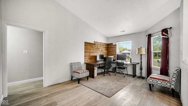 office area featuring a textured ceiling, high vaulted ceiling, and light wood-type flooring