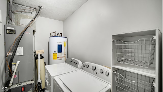 laundry area featuring heating unit, a textured ceiling, washer and clothes dryer, and water heater