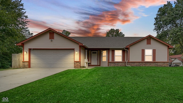 ranch-style house featuring a yard and a garage