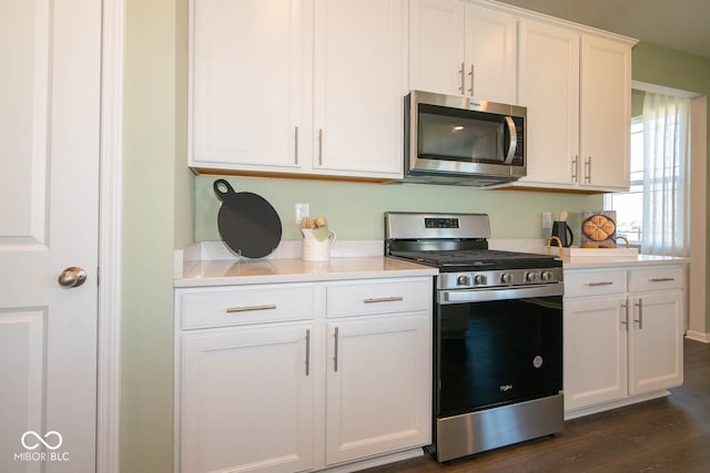 kitchen featuring white cabinetry, dark wood-type flooring, and appliances with stainless steel finishes