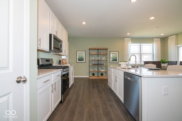 kitchen featuring appliances with stainless steel finishes, sink, a center island with sink, and white cabinets