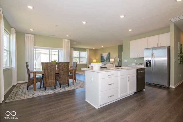 kitchen featuring sink, appliances with stainless steel finishes, dark hardwood / wood-style floors, an island with sink, and white cabinets