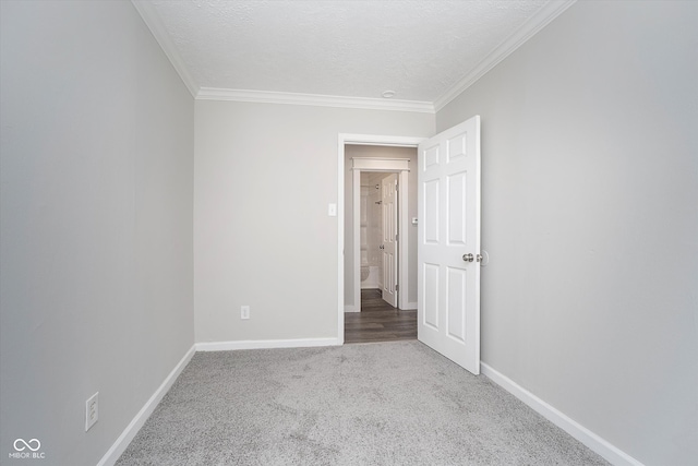 carpeted empty room featuring ornamental molding and a textured ceiling