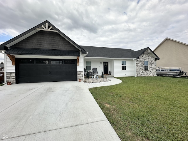view of front of home with a garage, a front yard, driveway, and stone siding