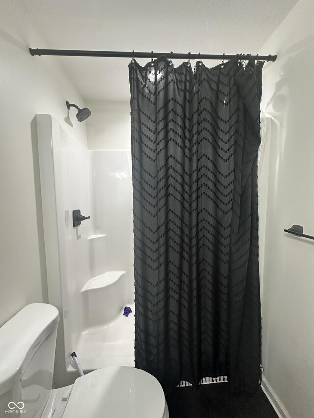 bathroom featuring baseboards, toilet, and a shower with curtain