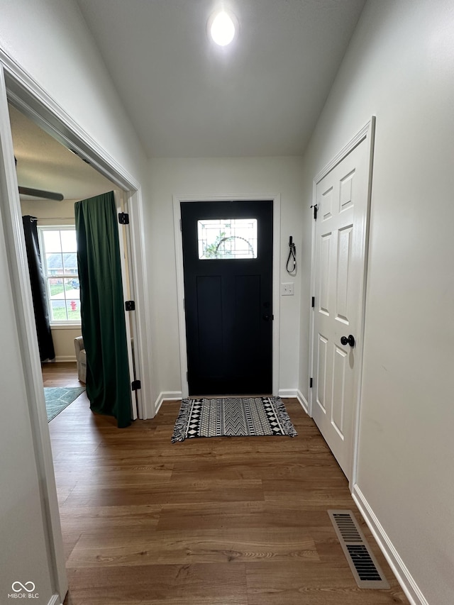 entryway featuring baseboards, wood finished floors, and visible vents