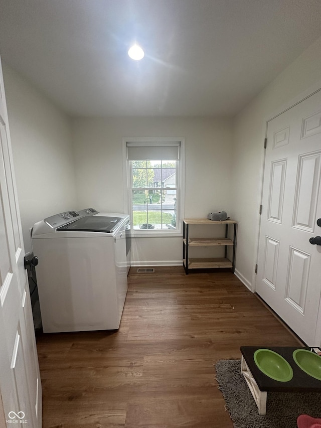laundry room with baseboards, laundry area, wood finished floors, and washer and dryer