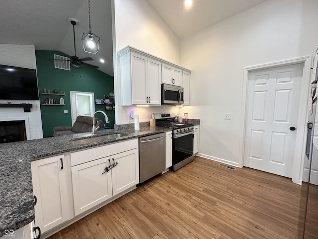 kitchen with stainless steel appliances, high vaulted ceiling, visible vents, and a sink