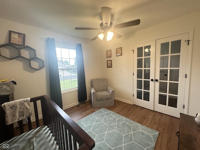 bedroom featuring baseboards, french doors, visible vents, and wood finished floors