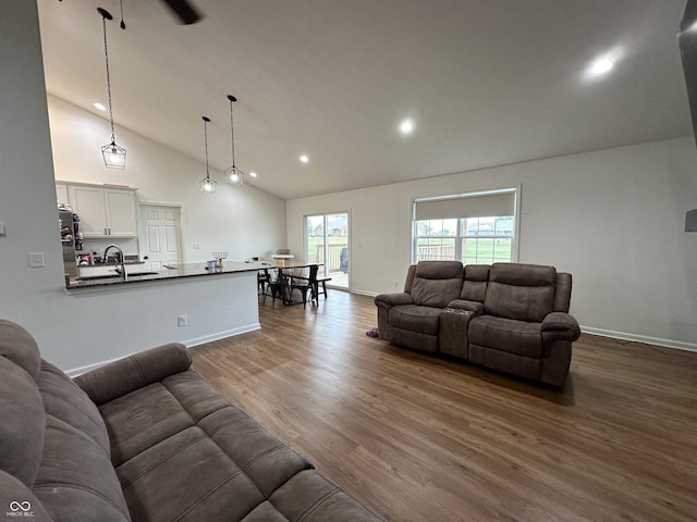 living area with baseboards, dark wood-style flooring, recessed lighting, and high vaulted ceiling