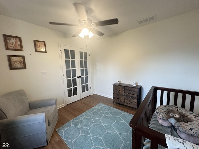 bedroom with a ceiling fan, french doors, visible vents, baseboards, and dark wood-type flooring