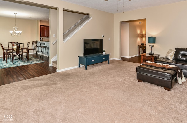 living room with wood-type flooring, a textured ceiling, and ceiling fan with notable chandelier