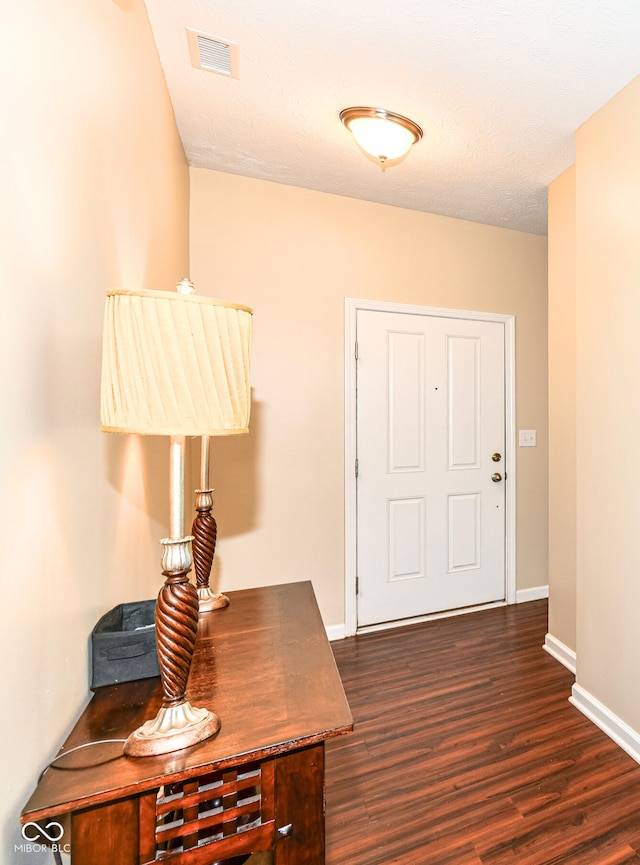 foyer with a textured ceiling and dark hardwood / wood-style floors