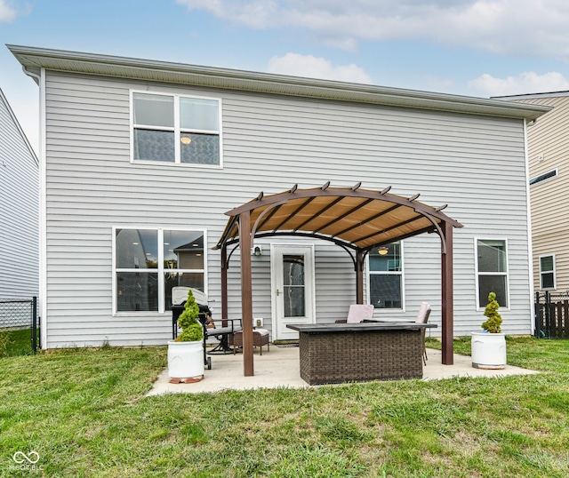 rear view of property featuring a yard, a patio, and a pergola