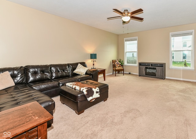 living room with a wealth of natural light, light carpet, and ceiling fan