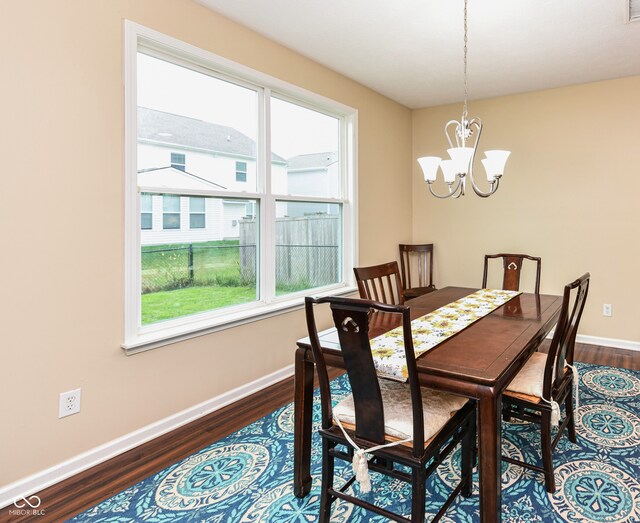 dining space featuring wood-type flooring and a chandelier