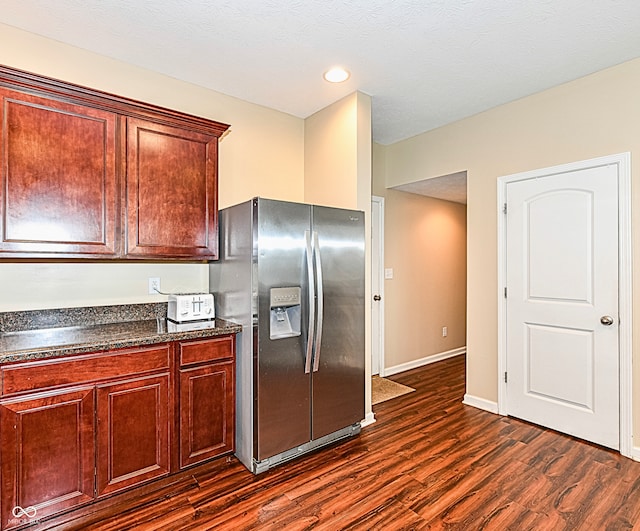 kitchen featuring a textured ceiling, dark hardwood / wood-style floors, and stainless steel fridge