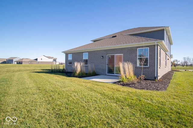 rear view of property with a lawn and a patio area