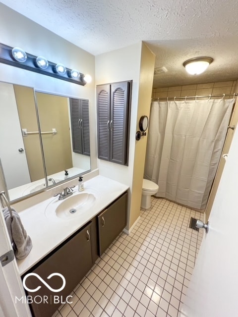 bathroom with a textured ceiling, toilet, vanity, a shower with curtain, and tile patterned floors