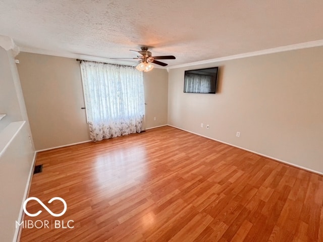 unfurnished room featuring light hardwood / wood-style floors, crown molding, a textured ceiling, and ceiling fan