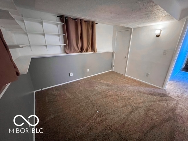 unfurnished room featuring carpet floors and a textured ceiling