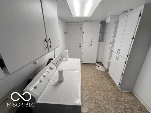 washroom featuring cabinets, separate washer and dryer, and light colored carpet