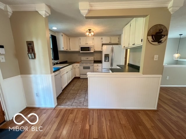 kitchen with white appliances, dark hardwood / wood-style flooring, and white cabinets