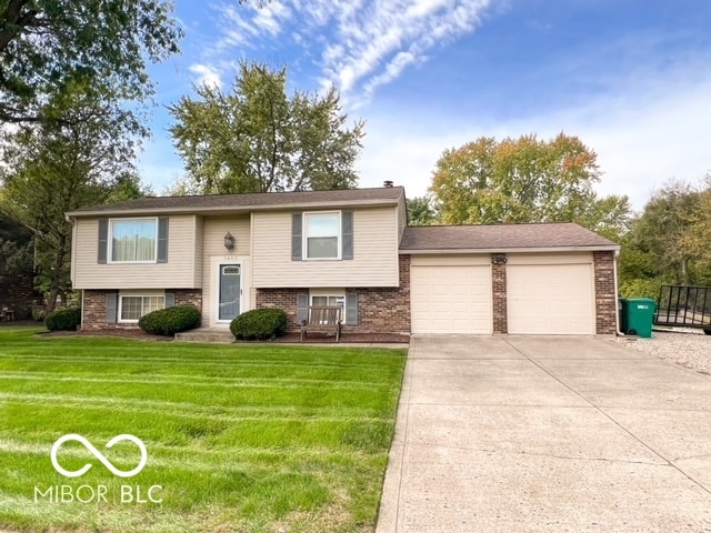 bi-level home with a front yard and a garage