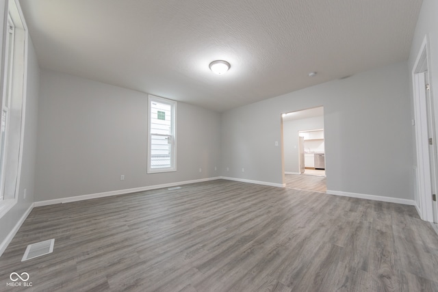 unfurnished room with wood-type flooring and a textured ceiling