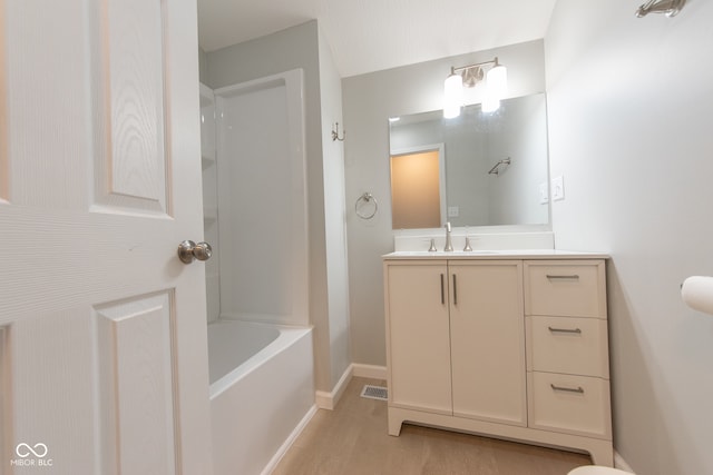 bathroom with hardwood / wood-style flooring, shower / washtub combination, and vanity