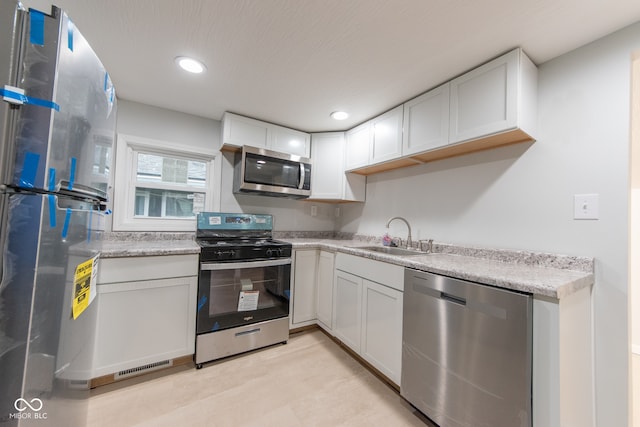 kitchen with white cabinets, stainless steel appliances, and sink