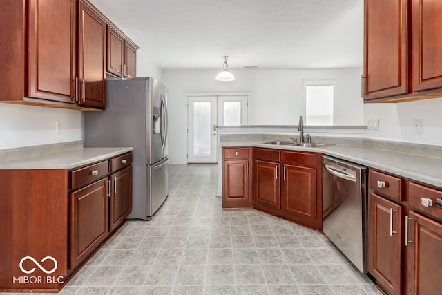 kitchen with appliances with stainless steel finishes, hanging light fixtures, and sink