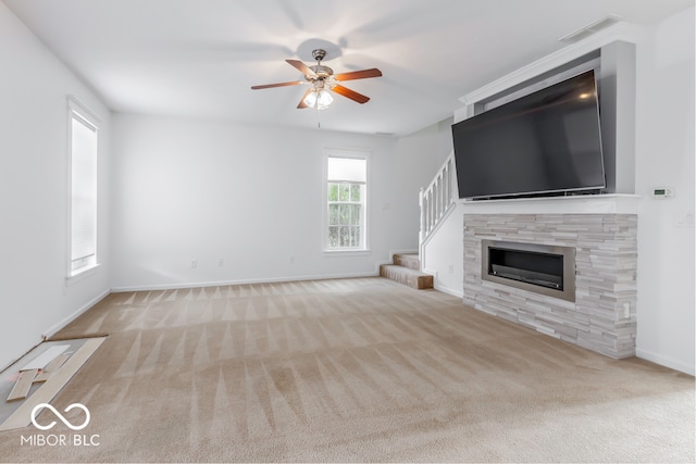 unfurnished living room featuring light carpet and ceiling fan