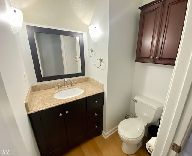 bathroom with hardwood / wood-style floors, vanity, and toilet