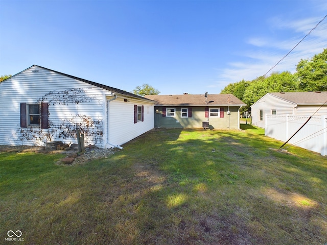 rear view of property featuring a yard