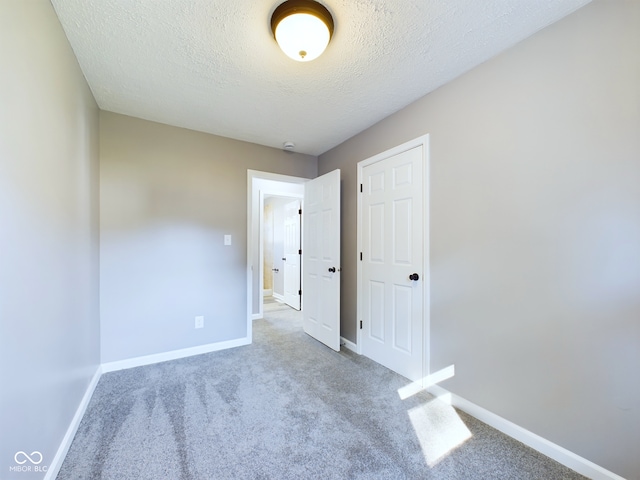 unfurnished room with a textured ceiling and carpet