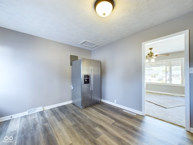 unfurnished room with ceiling fan, a textured ceiling, and dark hardwood / wood-style flooring