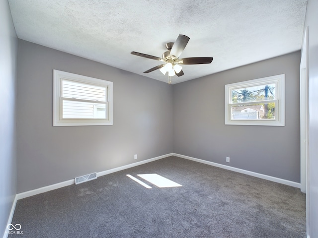 carpeted empty room featuring ceiling fan and a textured ceiling