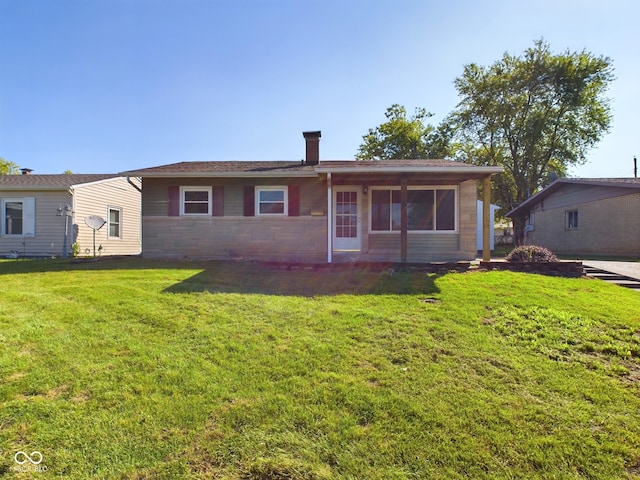 rear view of house featuring a yard