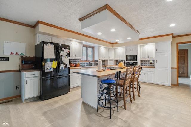 kitchen featuring visible vents, recessed lighting, white cabinetry, black appliances, and ornamental molding