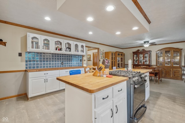 kitchen with light wood finished floors, butcher block counters, black gas range oven, and ornamental molding