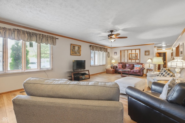 living room featuring light wood finished floors, a ceiling fan, baseboards, and crown molding