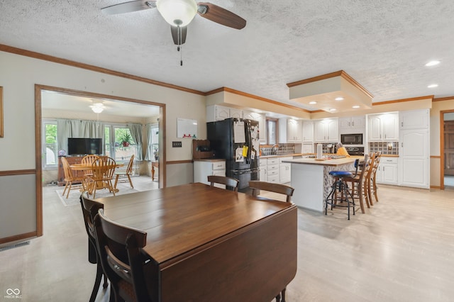 dining area with a textured ceiling, visible vents, recessed lighting, a ceiling fan, and ornamental molding
