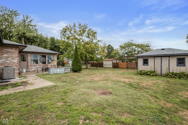 view of yard featuring a storage unit and central air condition unit