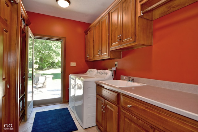 laundry area featuring cabinets, sink, washing machine and clothes dryer, and light tile patterned flooring